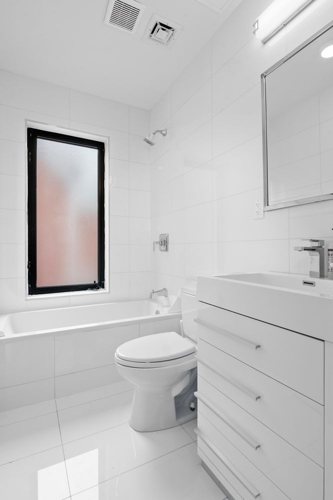 296 Fenimore Street Brooklyn, NY 11225 - Photo 16 of 19 a bathroom with a toilet sink and mirror