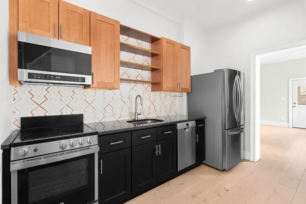 a kitchen with stainless steel appliances granite countertop a refrigerator and a stove