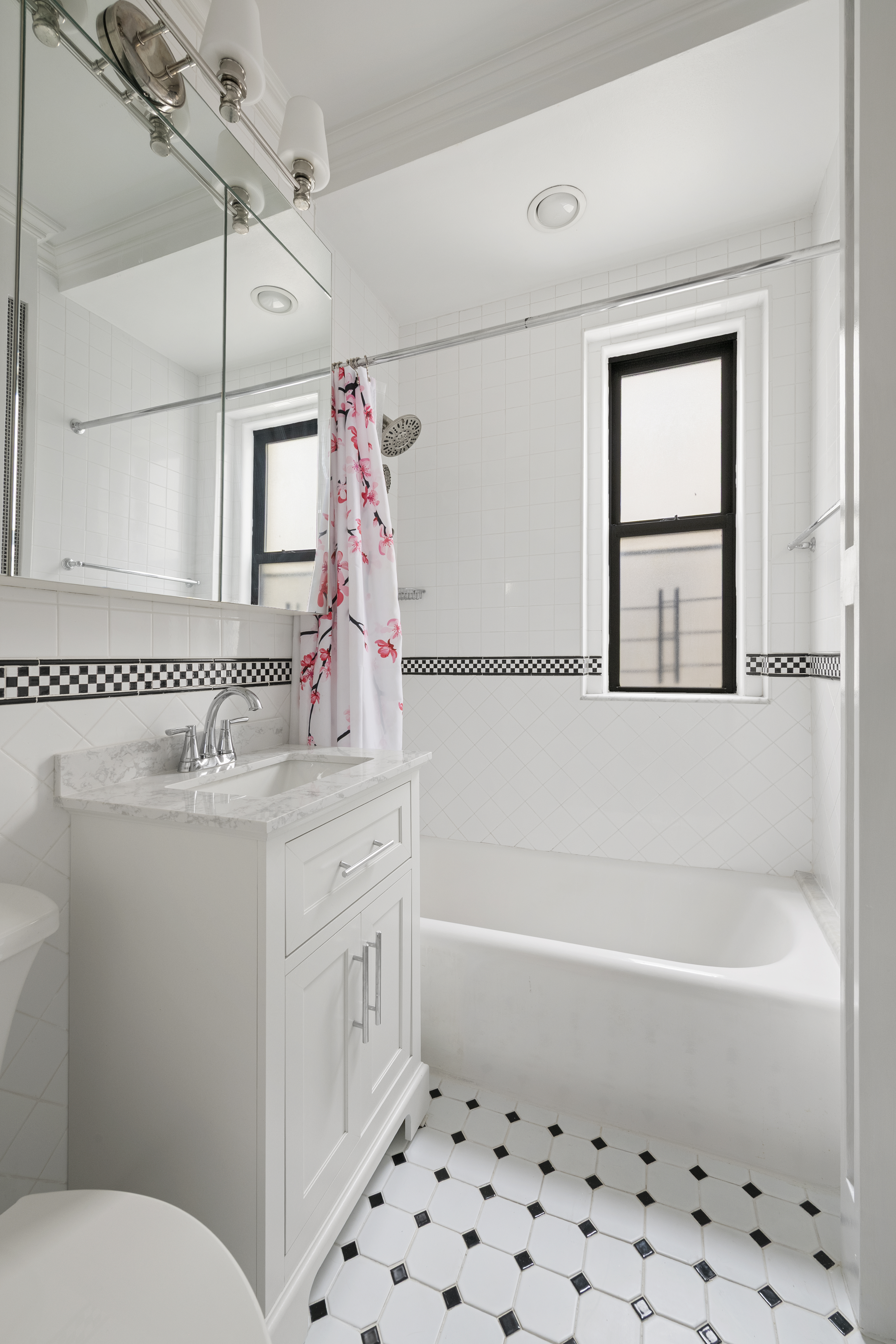 222 East 82nd Street, Unit 5E Manhattan, NY 10028 - Photo 7 of 10 a bathroom with a sink a toilet and shower