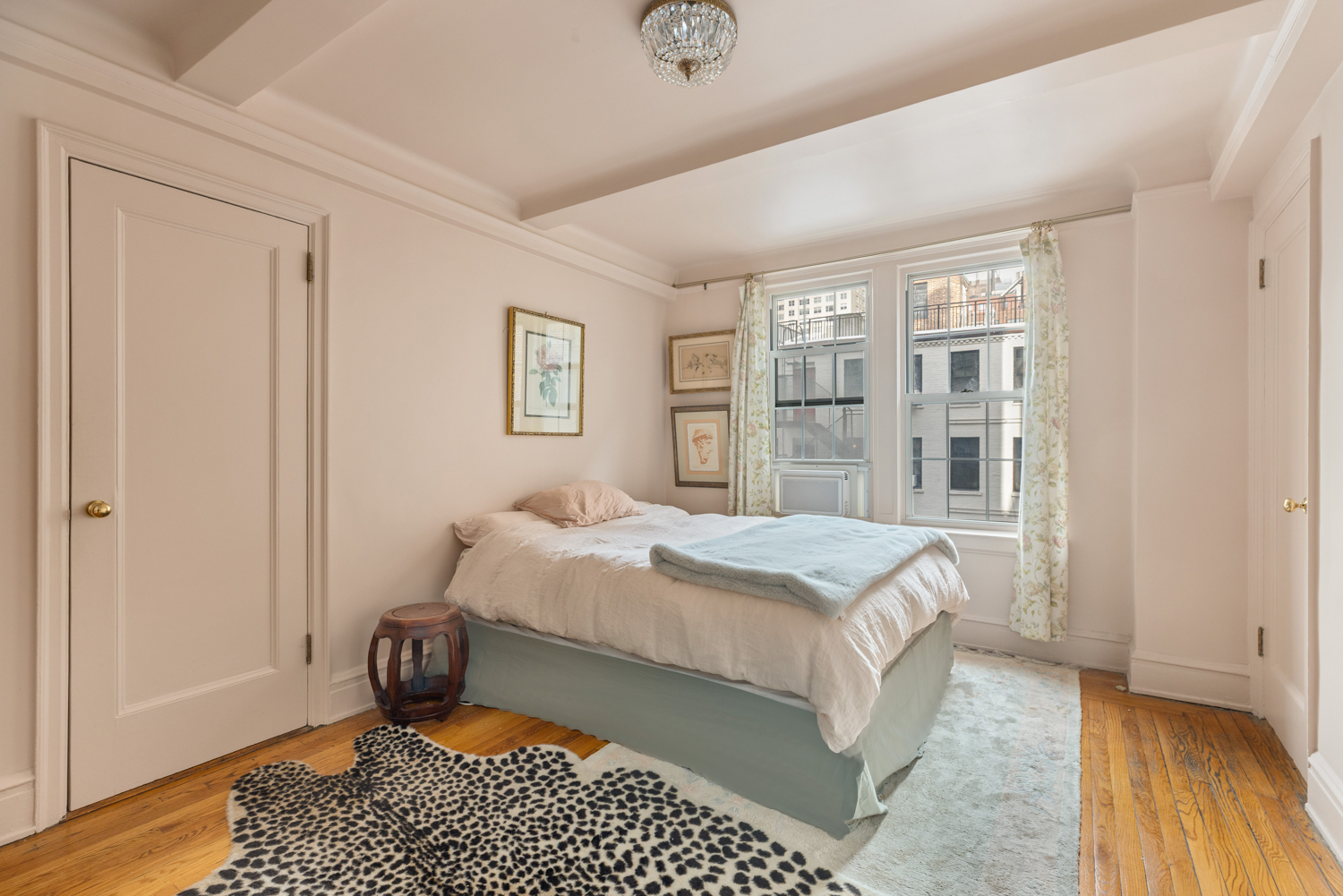 333 East 53rd Street, Unit 5M Manhattan, NY 10022 - Photo 3 of 8 a bedroom with a bed and wooden floor