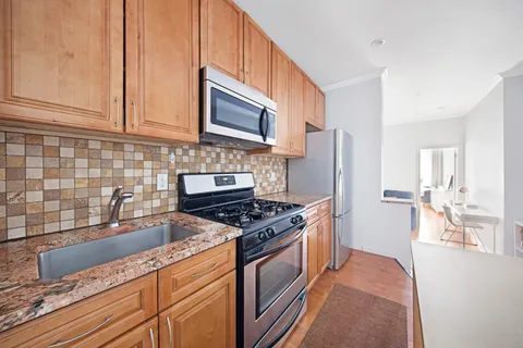 a kitchen with stainless steel appliances granite countertop a refrigerator stove and sink