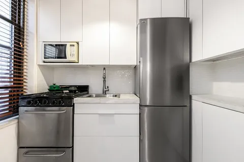 a kitchen with a refrigerator and a stove top oven