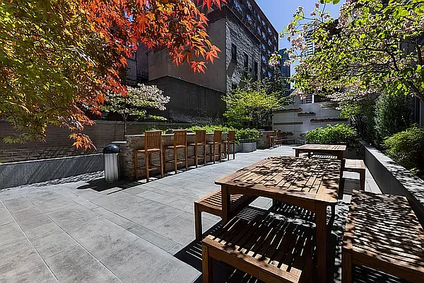 225 East 34th Street, Unit 14C Manhattan, NY 10016 - Photo 14 of 17 a view of a patio with table and chairs with wooden fence and plants