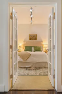 a bedroom with a bed and wooden floor