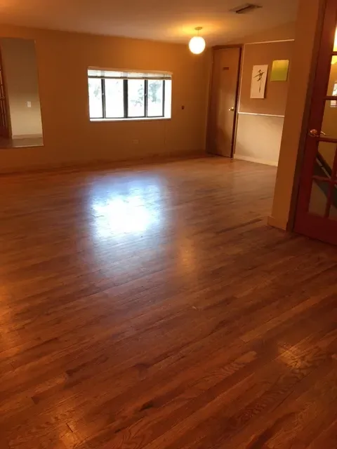 a view of wooden floor and windows in an empty room