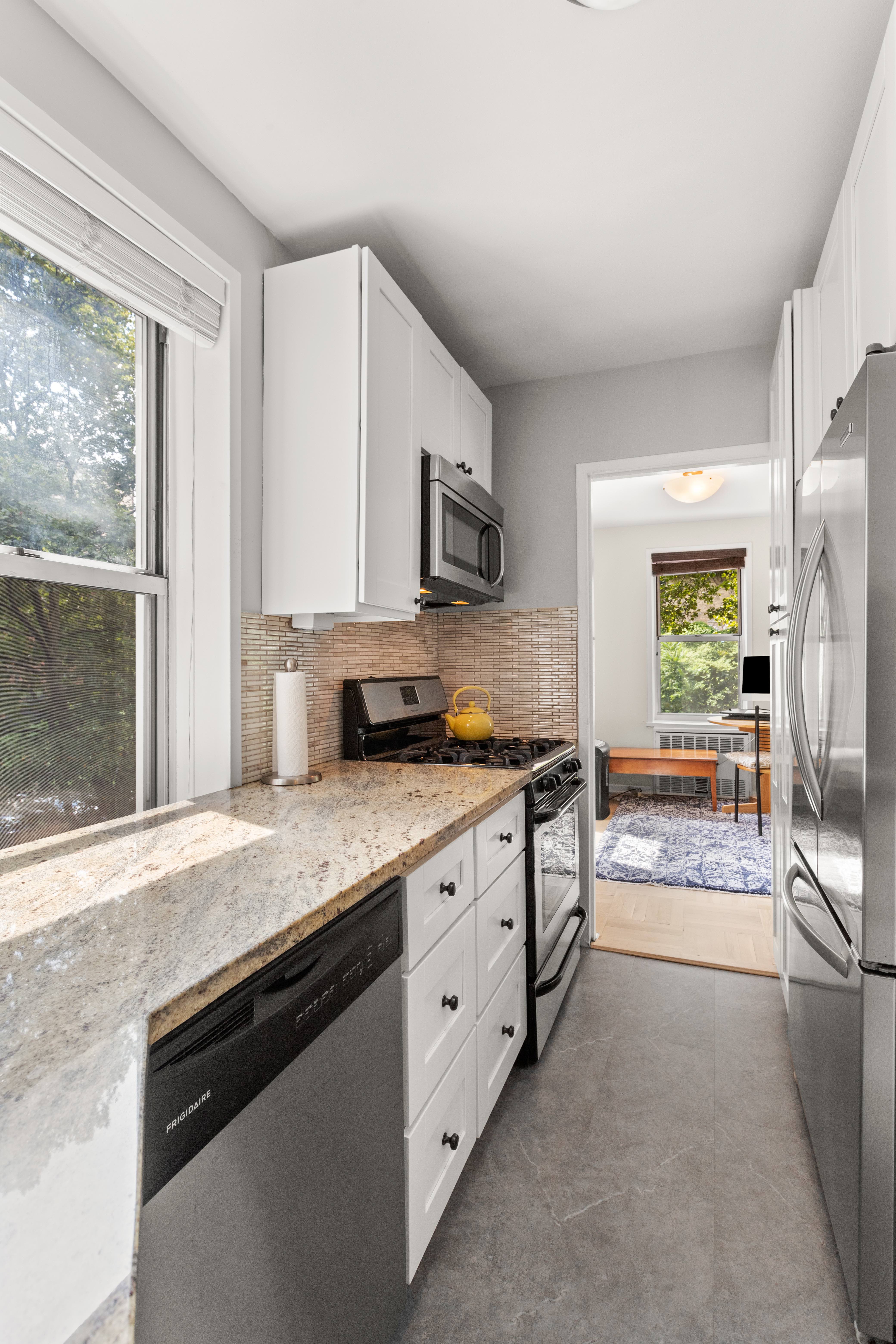 66 Overlook Terrace, Unit 4K Manhattan, NY 10040 - Photo 8 of 26 a kitchen with stainless steel appliances granite countertop a stove a sink and a refrigerator