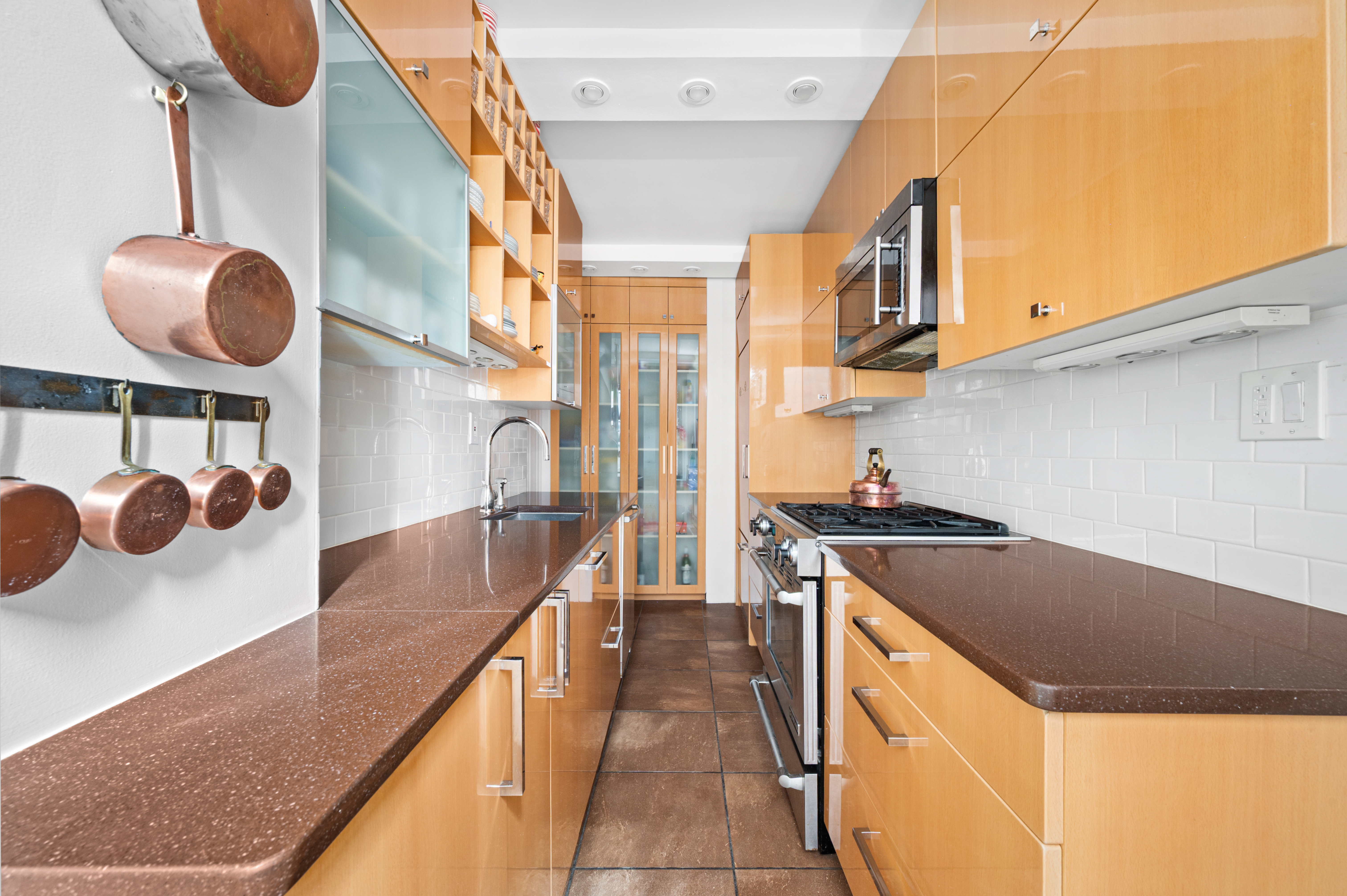 325 East 57th Street, Unit 11D Manhattan, NY 10022 - Photo 5 of 13 a kitchen with stainless steel appliances granite countertop a sink and a stove