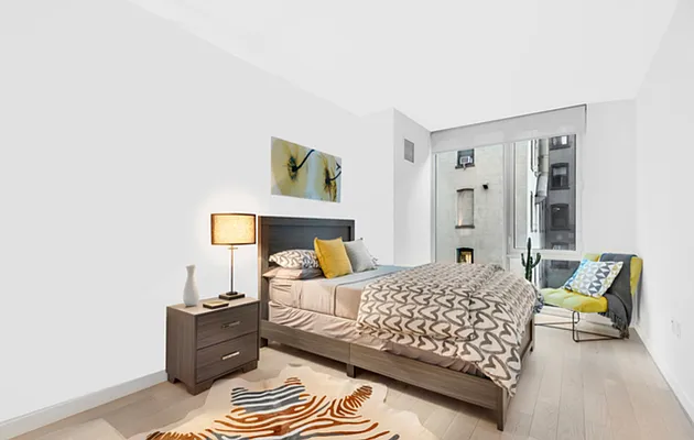 540 West 49th Street, Unit 206N Manhattan, NY 10019 - Photo 6 of 14 a bedroom with a bed and chair