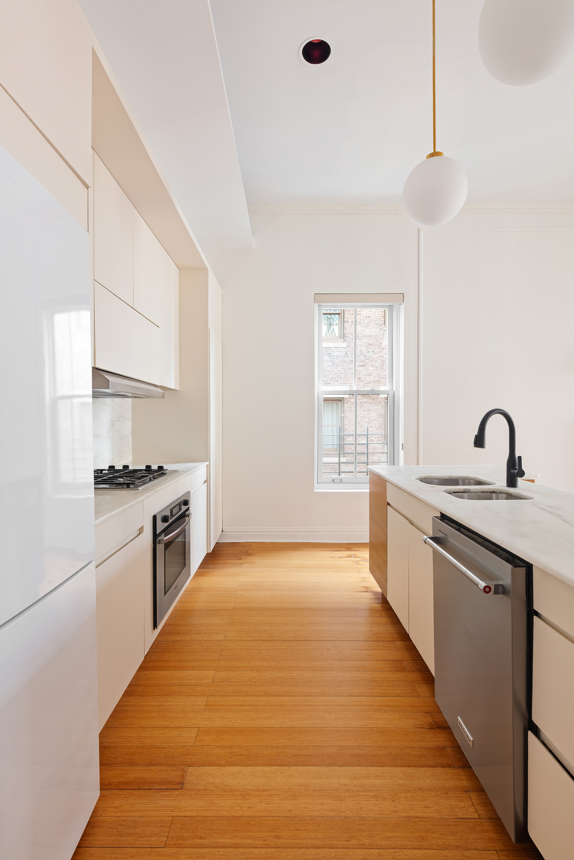 126 East 19th Street Manhattan, NY 10003 - Photo 12 of 13 a large kitchen with kitchen island a sink stainless steel appliances and cabinets