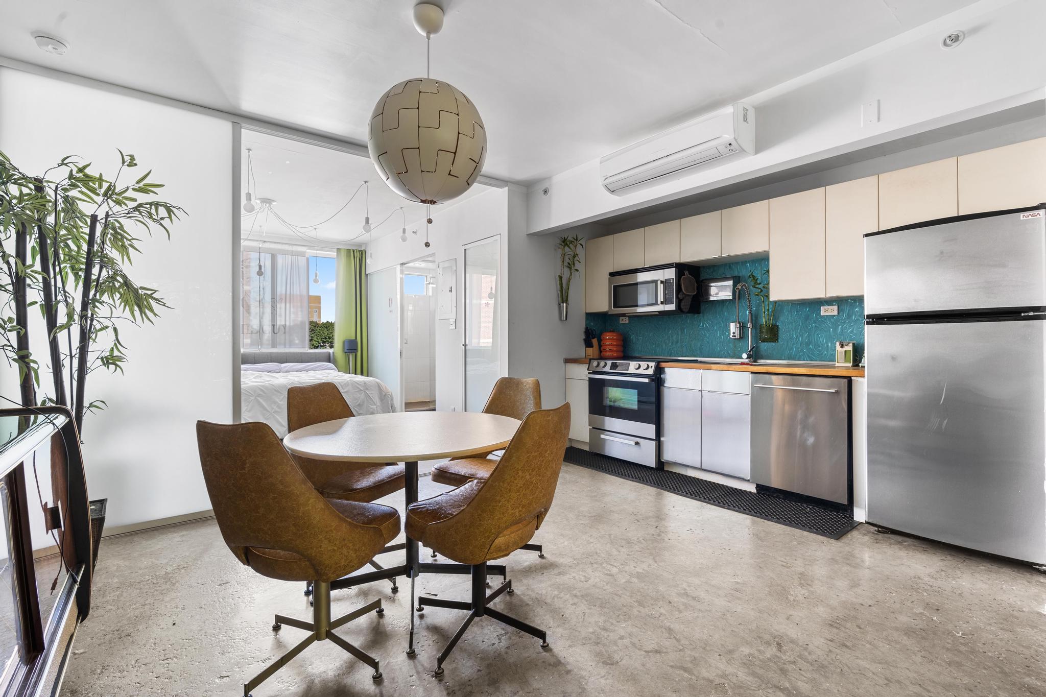 1311 Pacific Street, Unit 405 Brooklyn, NY 11216 - Photo 3 of 9 a kitchen with stainless steel appliances a dining table chairs and a refrigerator
