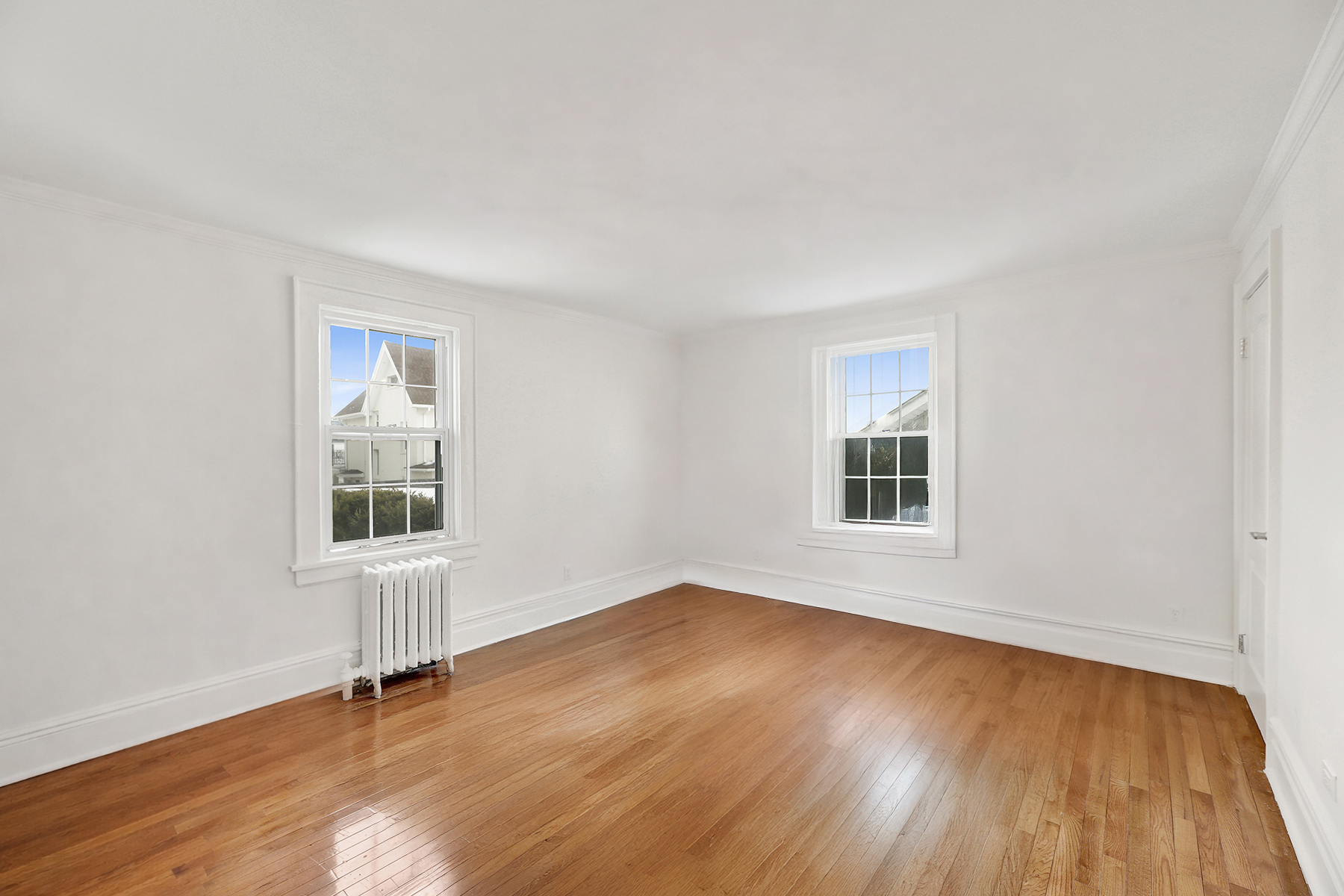 334 Beach 146th Street Queens, NY 11694 - Photo 8 of 21 an empty room with wooden floor and windows