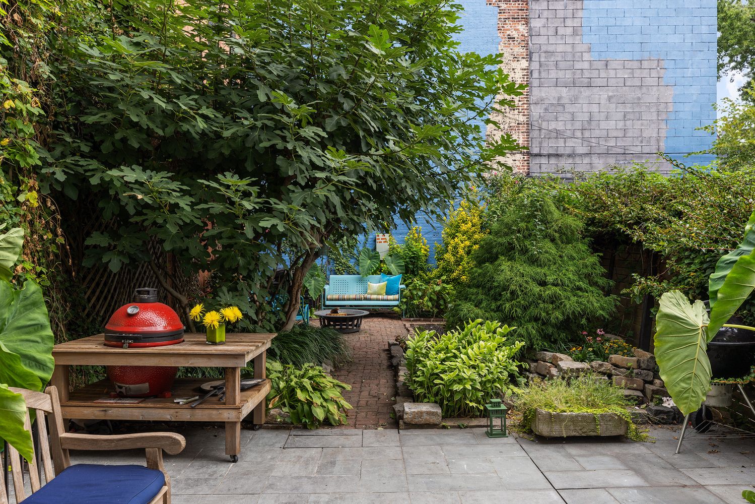a view of a backyard with plants and a fire pit
