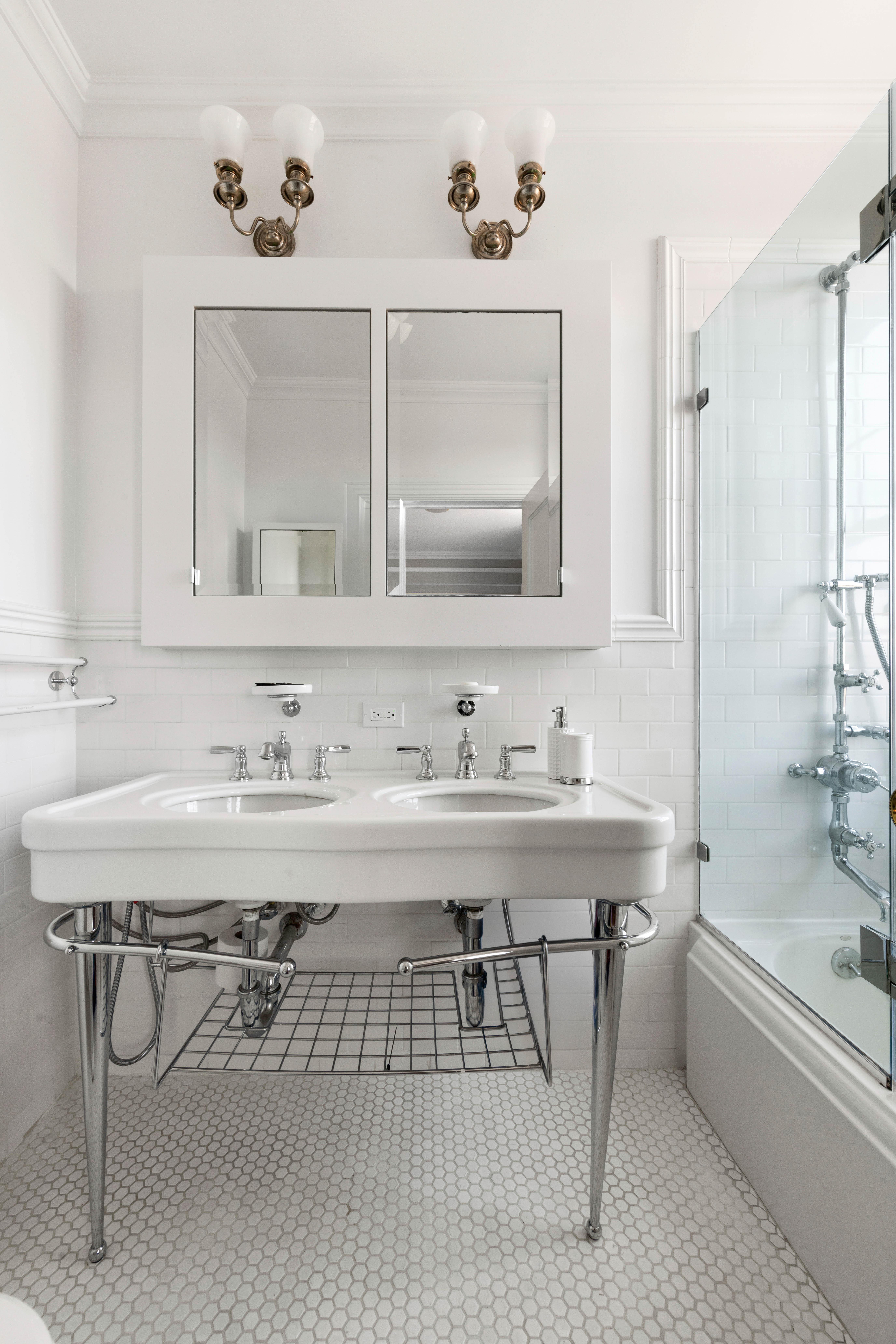 1140 5th Avenue, Unit 14B Manhattan, NY 10128 - Photo 11 of 18 a bathroom with a sink and a mirror