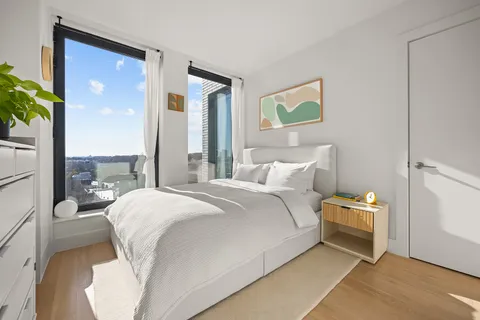 a bedroom with a bed and a potted plant