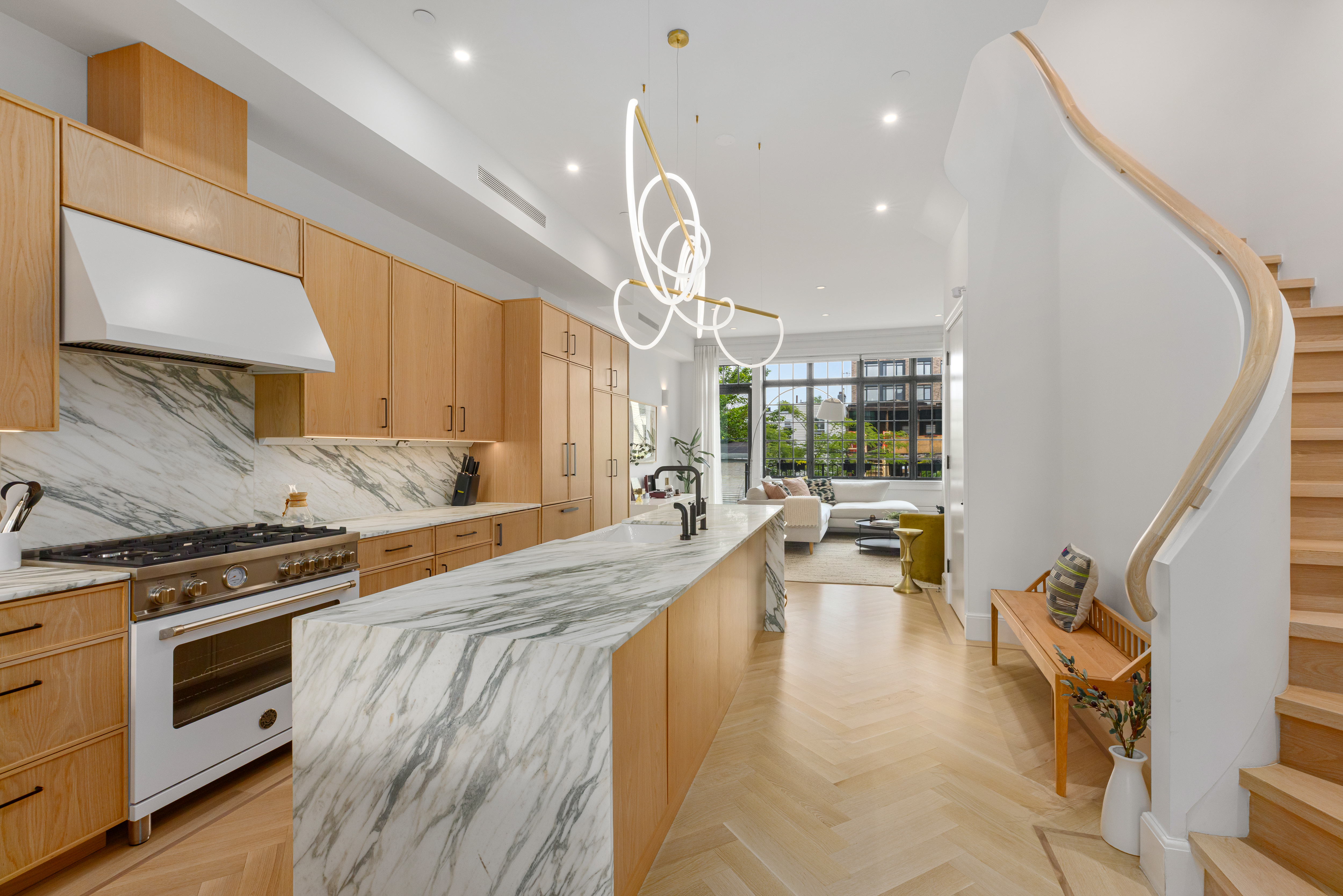 179 Devoe Street Brooklyn, NY 11211 - Photo 2 of 20 a large white kitchen with a large window a stove a sink and a refrigerator