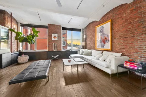 a living room with furniture fireplace and wooden floor