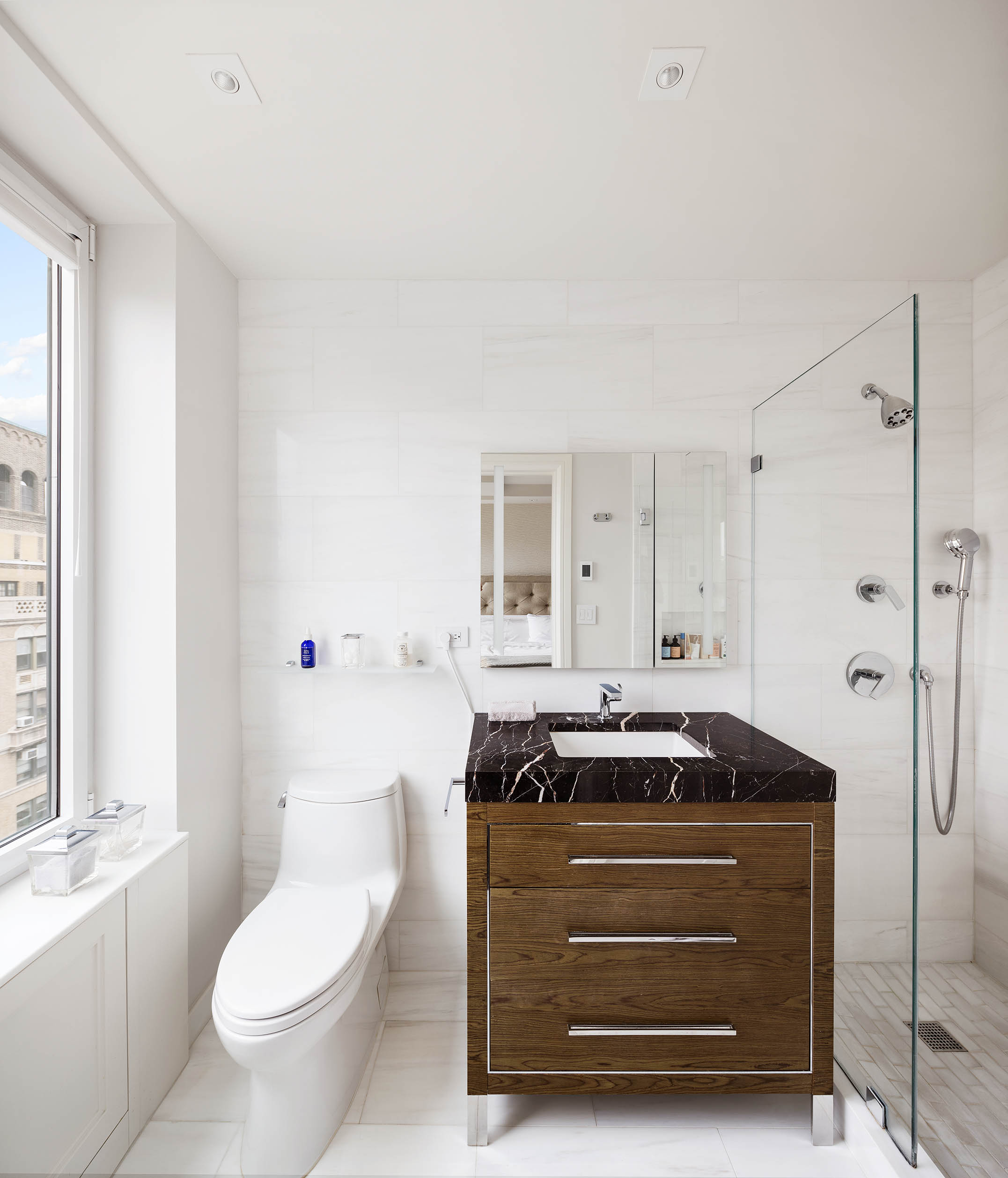 49 East 86th Street, Unit 17B Manhattan, NY 10028 - Photo 8 of 11 a bathroom with a granite countertop sink a toilet a mirror and shower