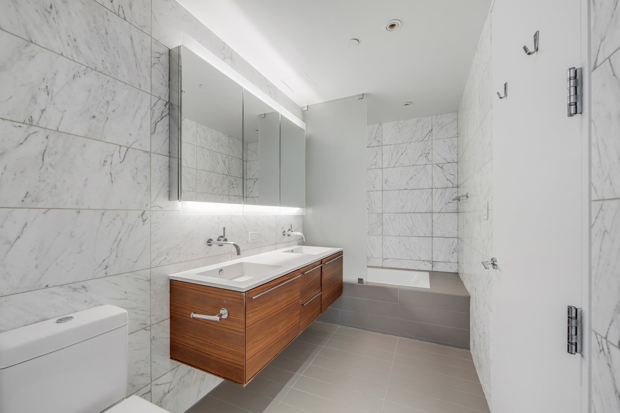 123 3rd Avenue, Unit 9C Manhattan, NY 10003 - Photo 10 of 16 a bathroom with a tub sink and mirror