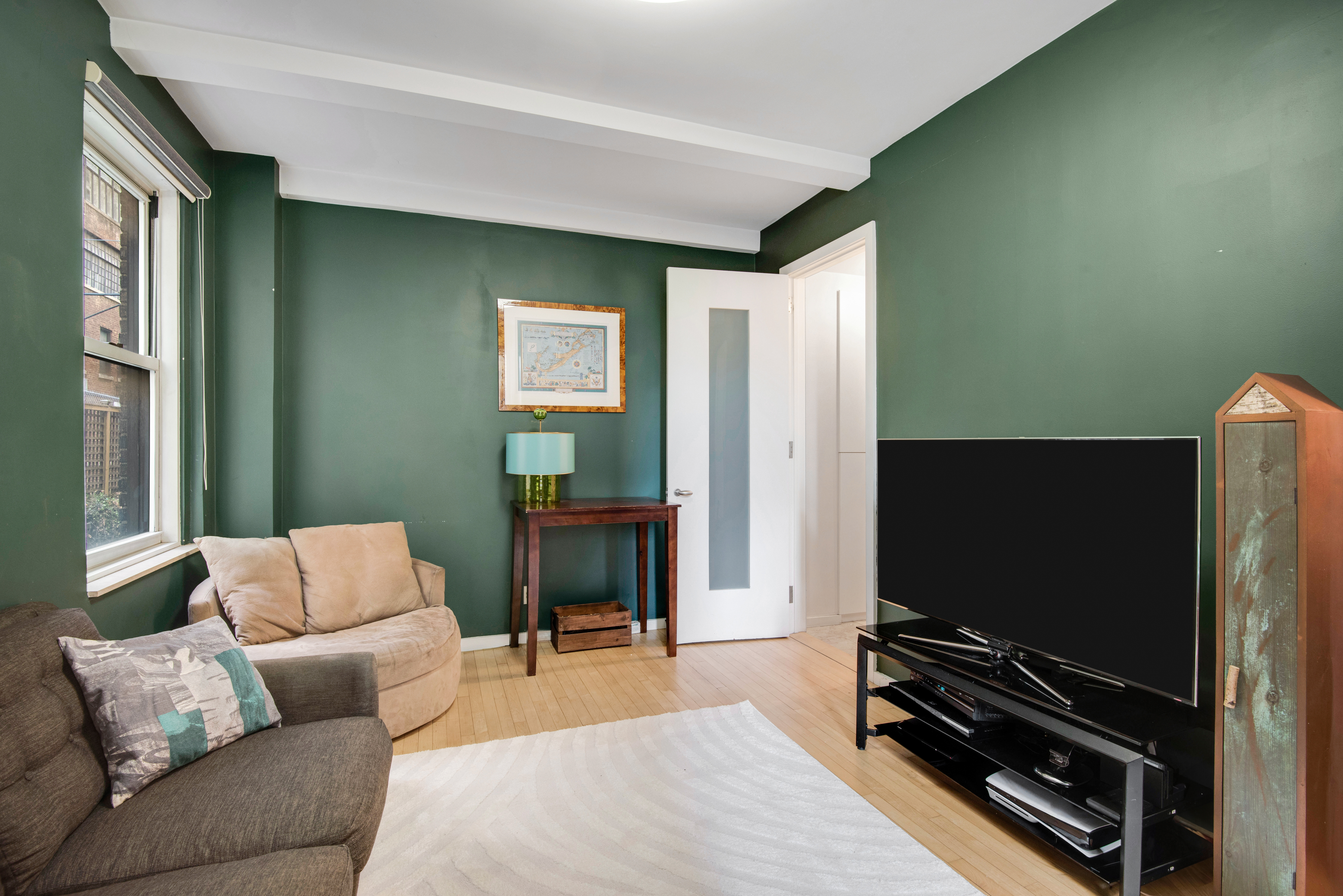 434 East 52nd Street, Unit 1BH Manhattan, NY 10022 - Photo 14 of 23 a living room with furniture and a flat screen tv