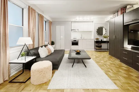 a living room with furniture rug and wooden floor