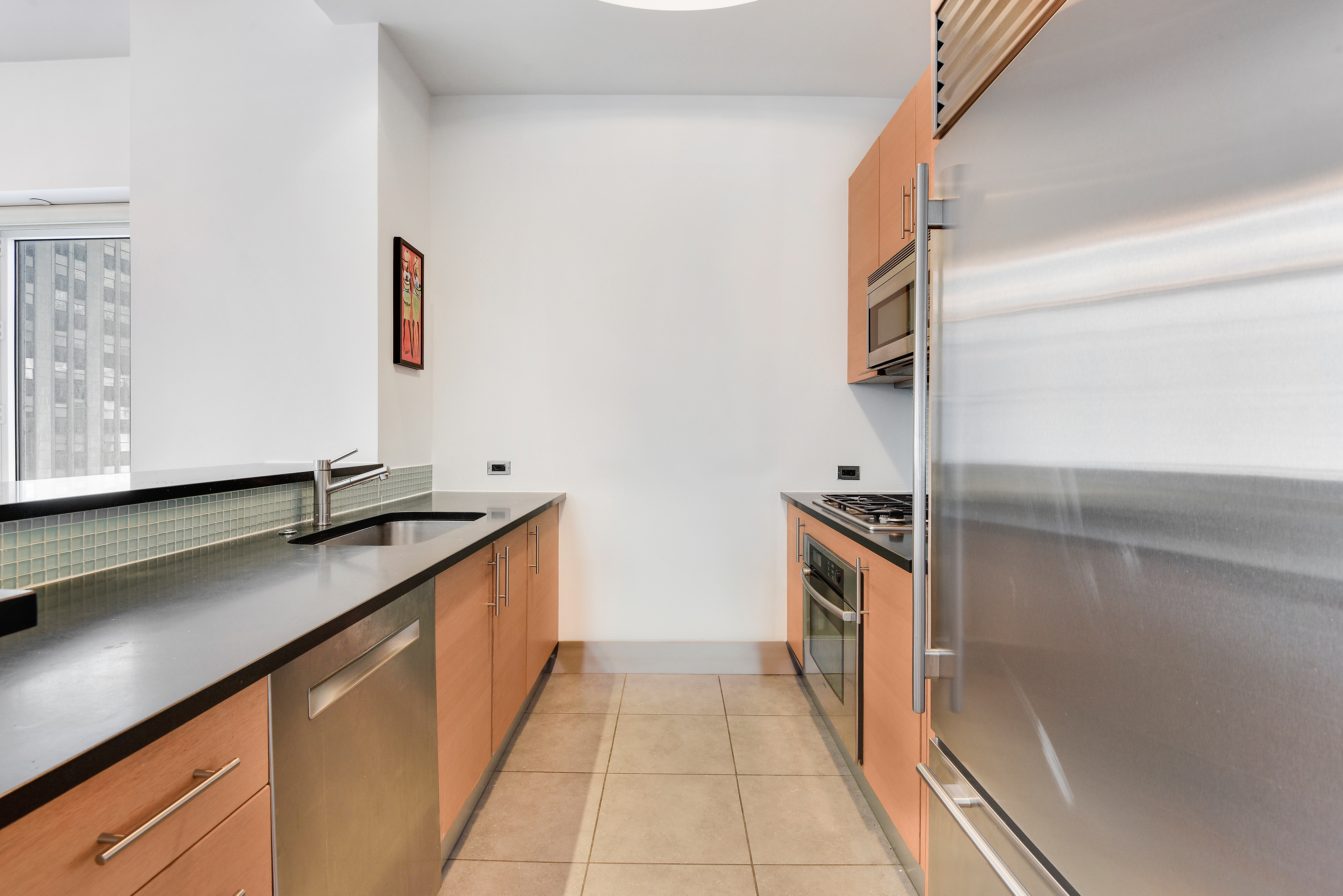 325 5th Avenue, Unit 16C Manhattan, NY 10016 - Photo 4 of 25 a kitchen with stainless steel appliances granite countertop a sink and a stove