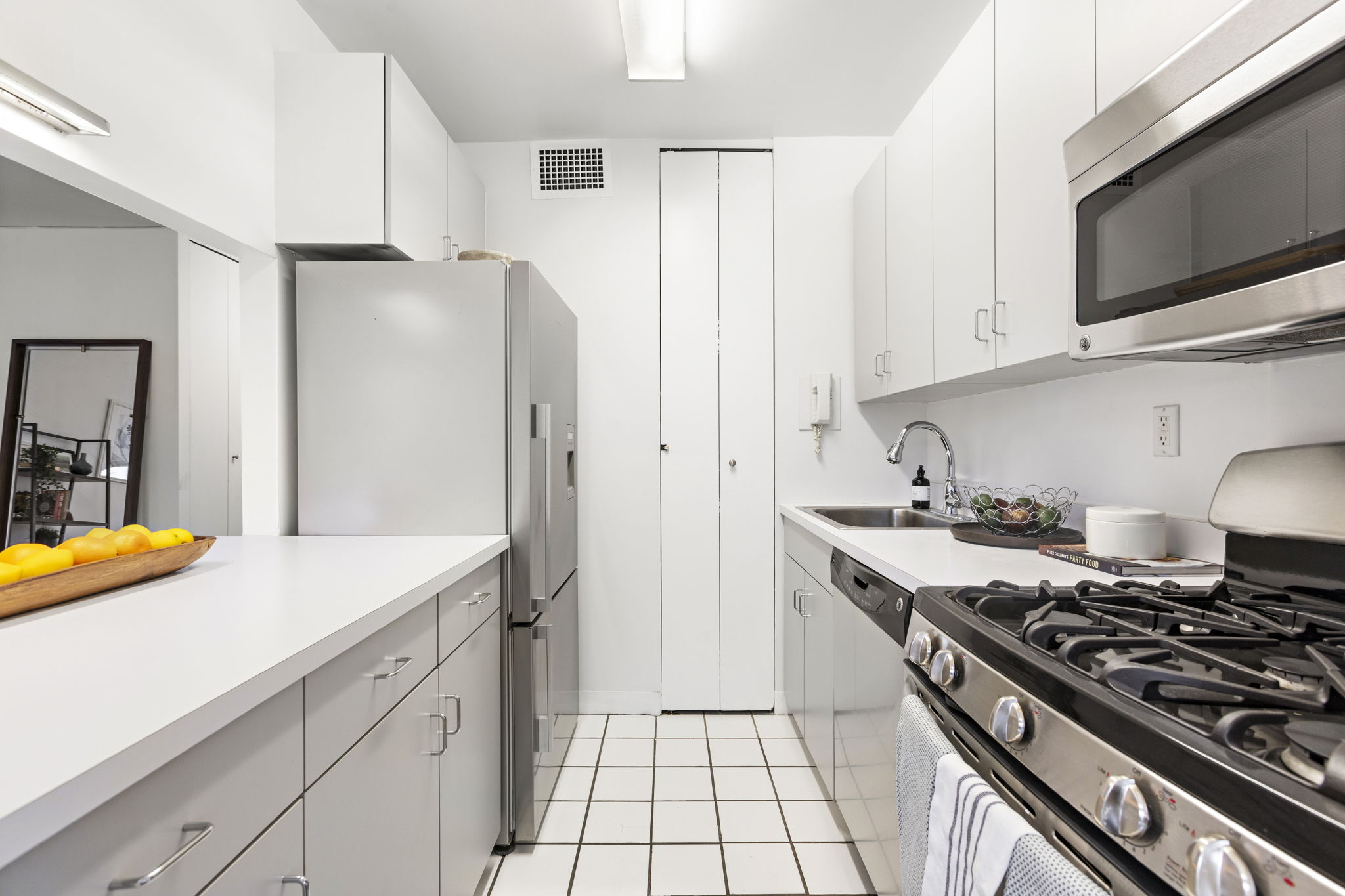 400 East 54th Street, Unit 18E Manhattan, NY 10022 - Photo 6 of 22 a kitchen with stainless steel appliances granite countertop a refrigerator and a sink