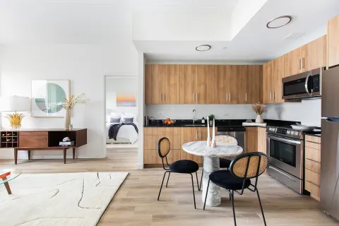 a kitchen with stainless steel appliances granite countertop a stove a sink a dining table and chairs