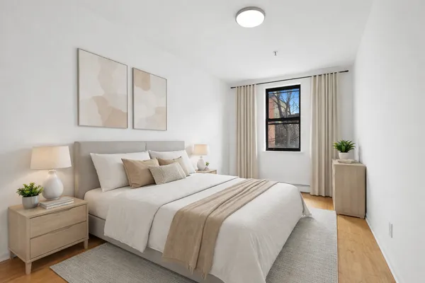 a bedroom with a bed painting on wall and a window