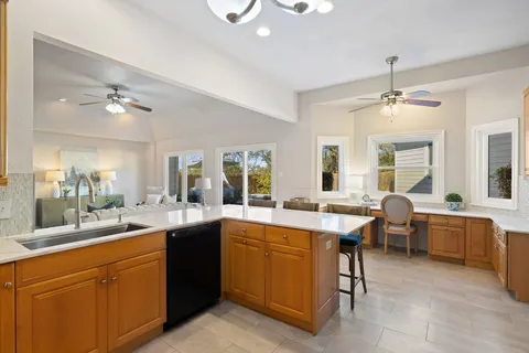 a large kitchen with a sink and dishwasher a stove with wooden floor