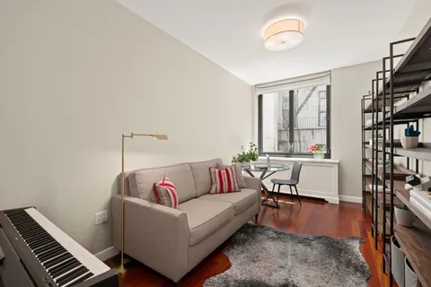 a living room with furniture and a book shelf