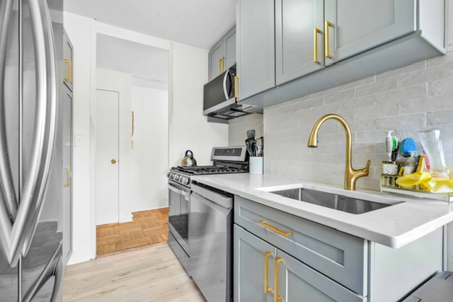 135 Ashland Place, Unit 5A Brooklyn, NY 11201 - Photo 5 of 12 a kitchen with stainless steel appliances granite countertop a sink and a refrigerator