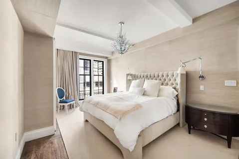 a bedroom with a bed a chandelier and a window