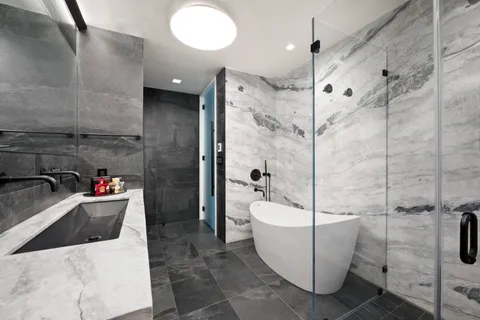 a bathroom with a sink a toilet and shower