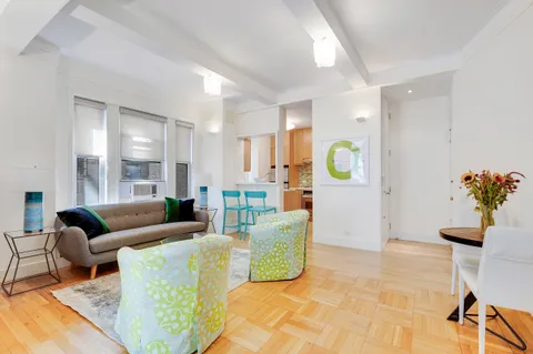 a living room with furniture and painting on the wall