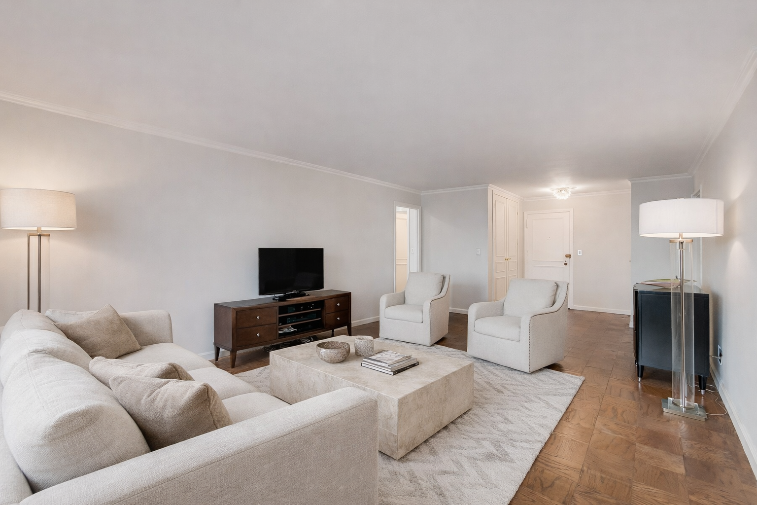 225 East 57th Street, Unit 5K Manhattan, NY 10022 - Photo 2 of 11 a living room with furniture and a flat screen tv
