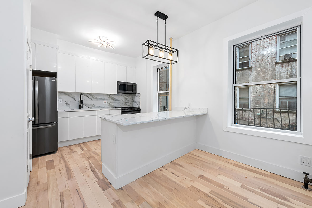 88 Brooklyn Avenue, Unit A3 Brooklyn, NY 11216 - Photo 7 of 12 a kitchen with kitchen island a counter top space a sink stainless steel appliances and cabinets