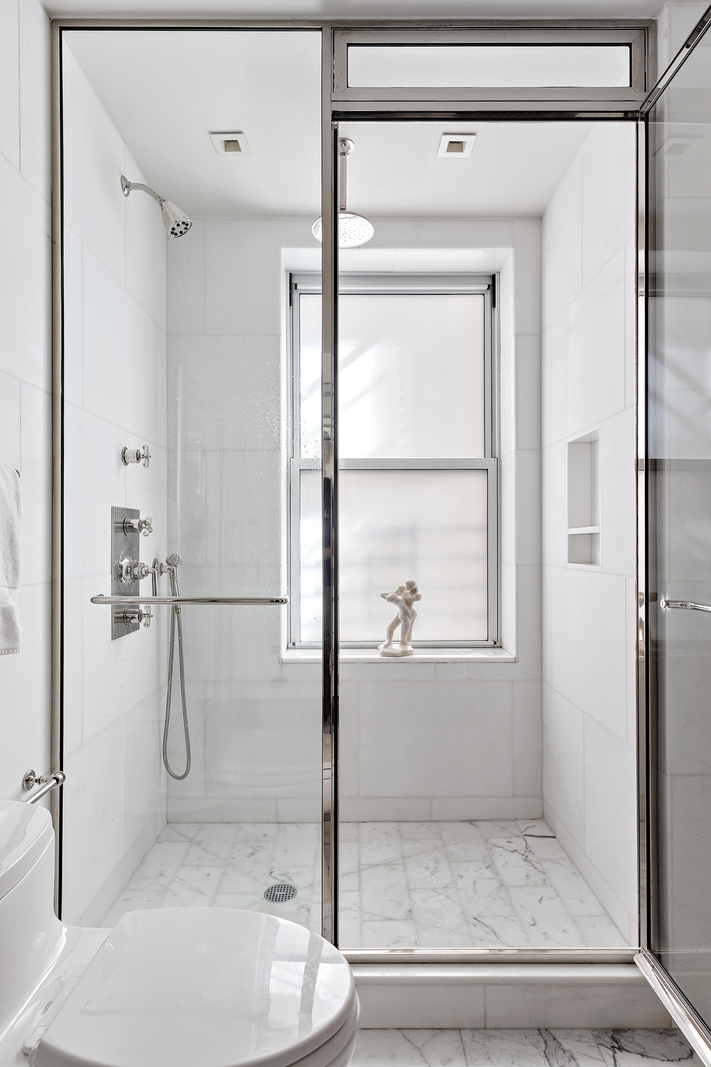 141 East 88th Street, Unit 7A Manhattan, NY 10128 - Photo 8 of 16 a bathroom with a glass shower door