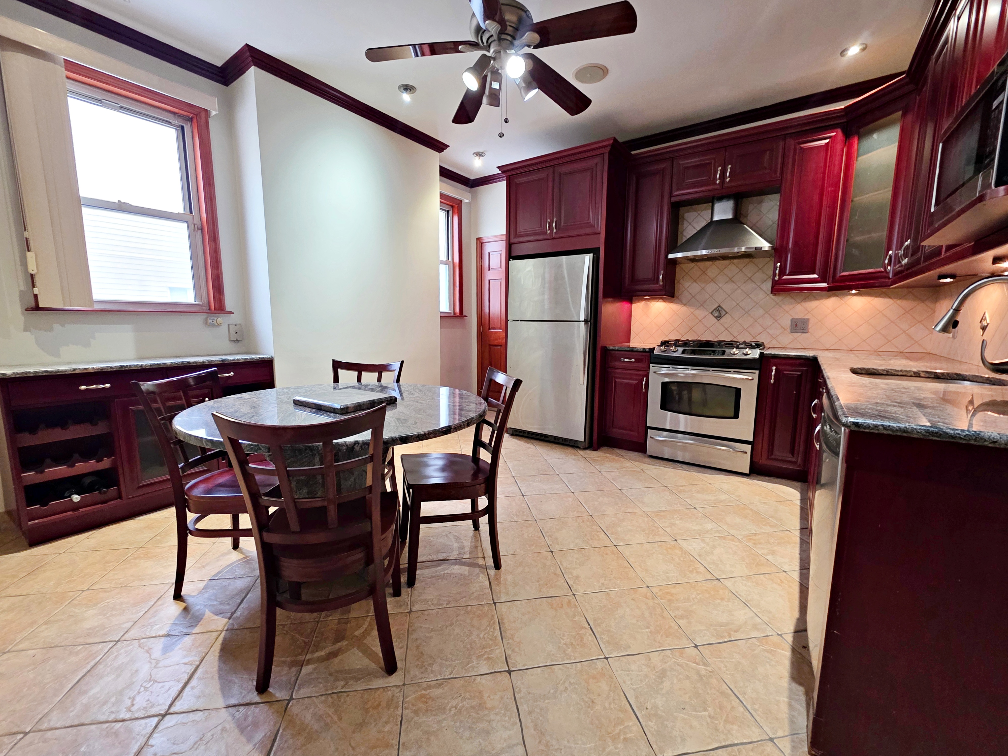 714 Lorimer Street, Unit 1 Brooklyn, NY 11211 - Photo 2 of 7 a kitchen with stainless steel appliances granite countertop a sink dishwasher a stove a refrigerator with a dining table and chairs
