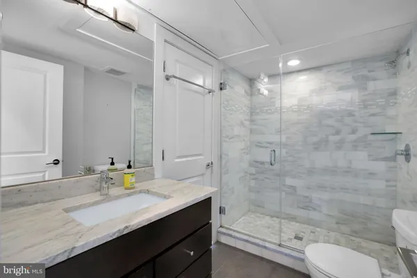 a bathroom with a granite countertop sink toilet and shower