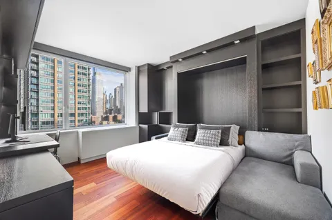 a bedroom with a bed and a large window