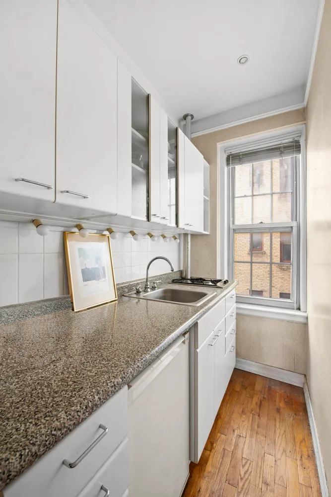a kitchen with granite countertop a sink and a stove top oven