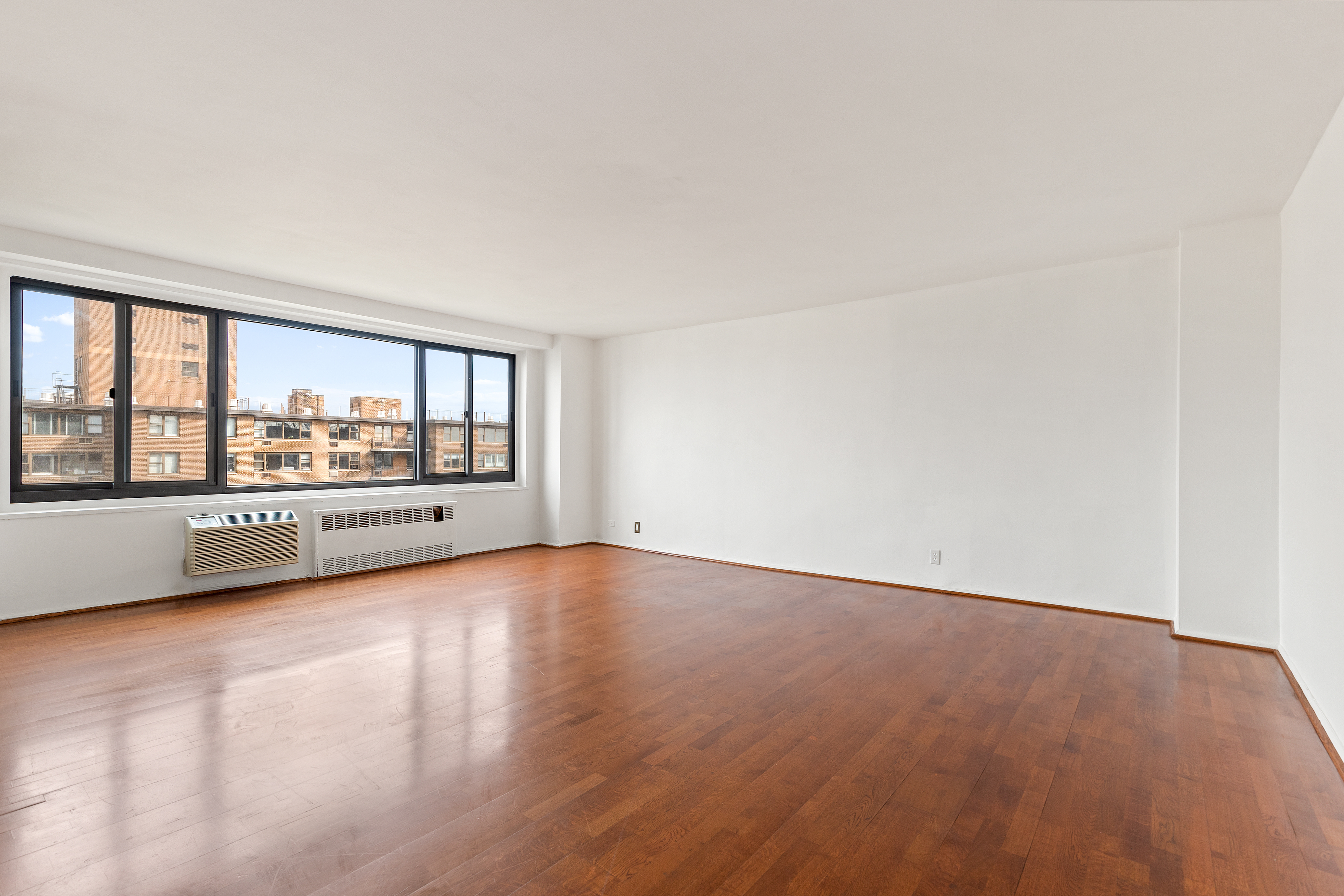 195 Willoughby Avenue, Unit 1612 Brooklyn, NY 11205 - Photo 4 of 10 a view of an empty room with a window and wooden floor