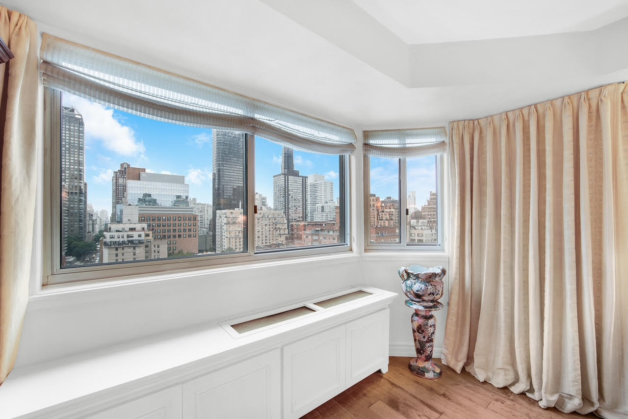 401 East 65th Street, Unit 16C Manhattan, NY 10065 - Photo 2 of 13 a living room with a large window and a wooden floor