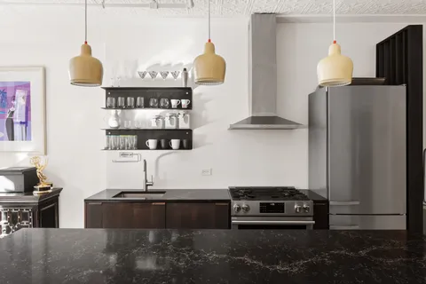 a kitchen with stainless steel appliances granite countertop a refrigerator and a stove