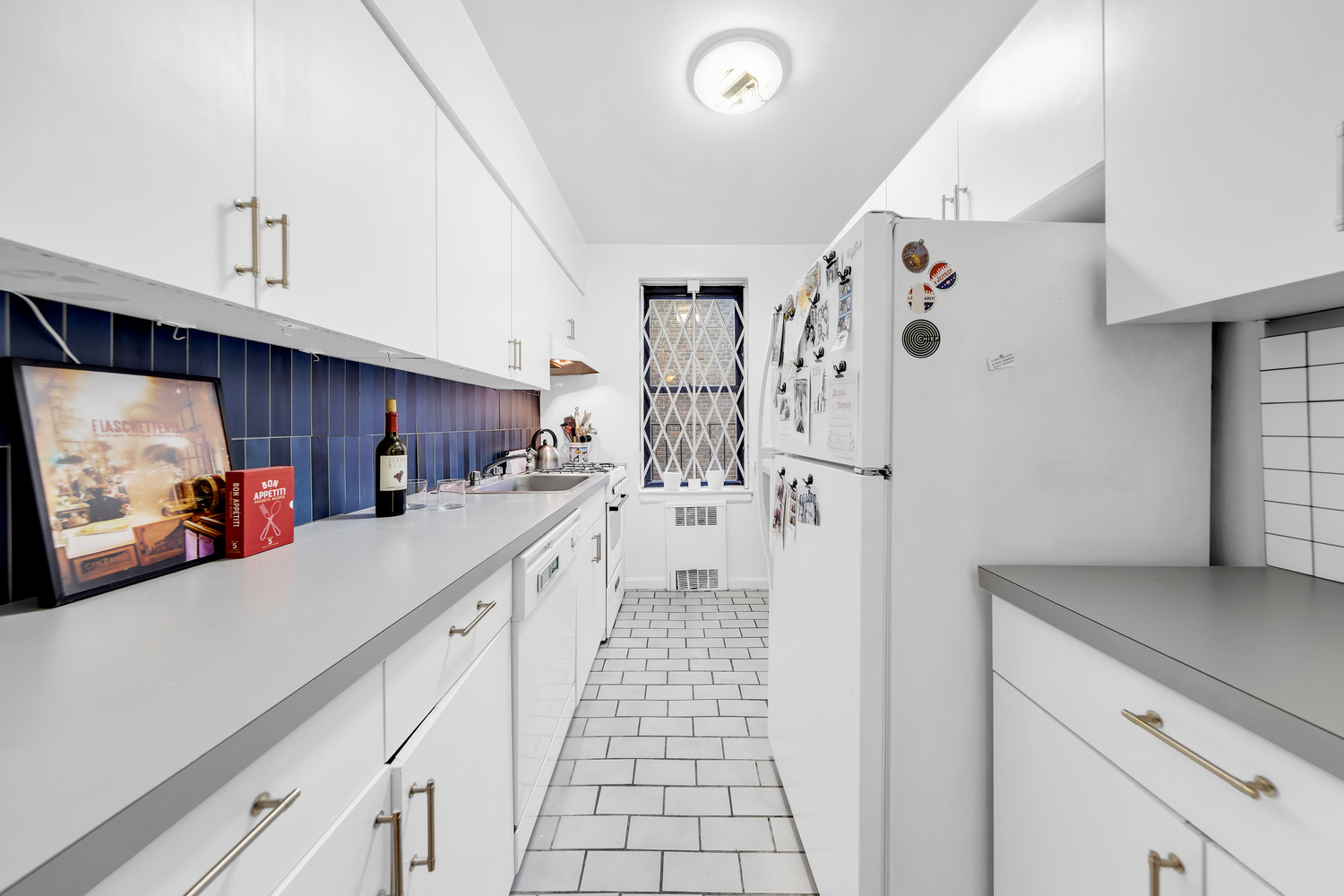 50-54 East 8th Street, Unit 3S Manhattan, NY 10003 - Photo 4 of 7 a kitchen with stainless steel appliances a refrigerator a sink and cabinets