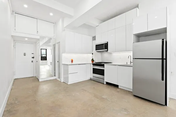 a kitchen with refrigerator cabinets and wooden floor