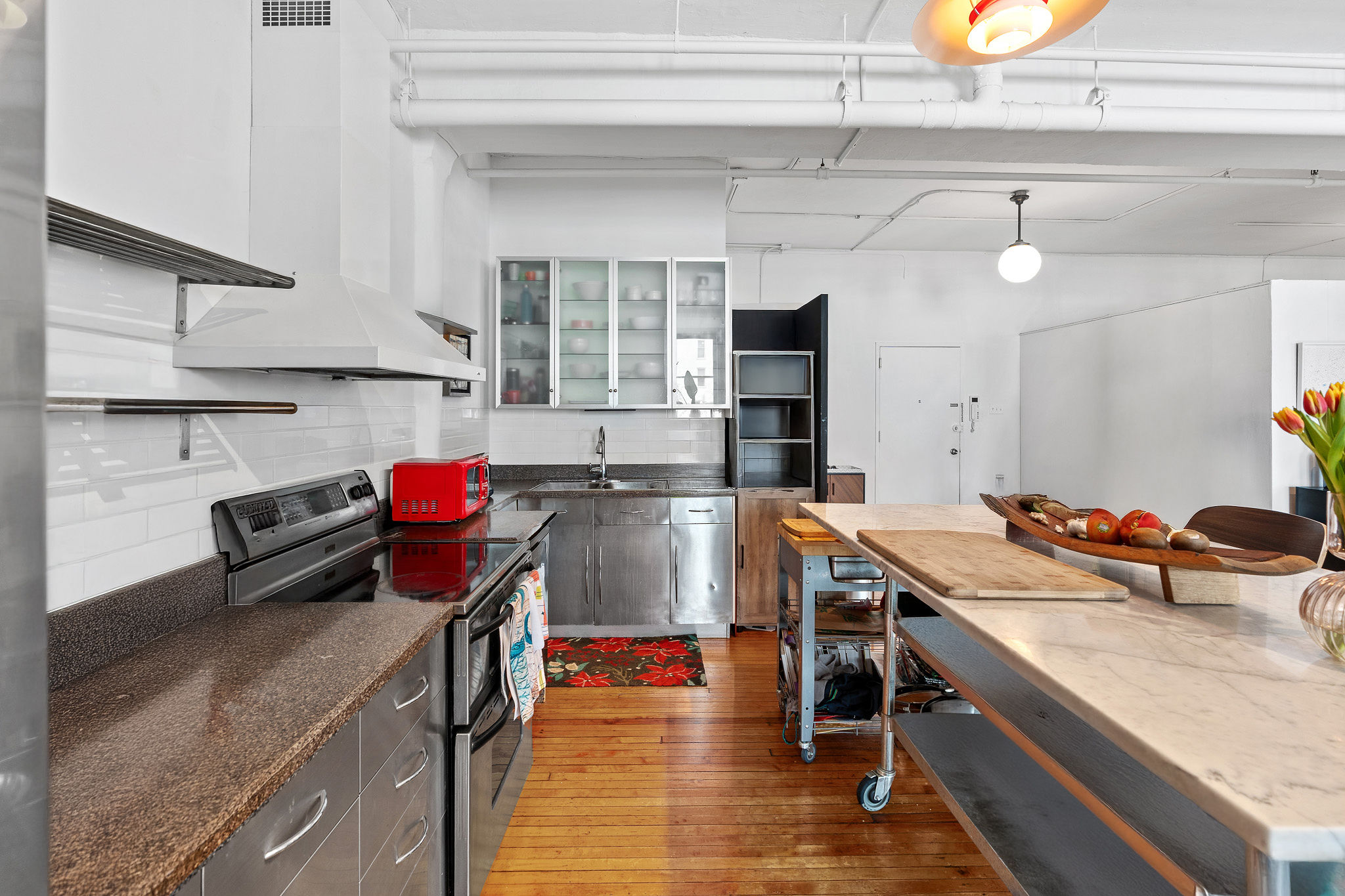 565 Broadway, Unit 8W Manhattan, NY 10012 - Photo 7 of 23 a kitchen with stainless steel appliances granite countertop a sink stove and cabinets