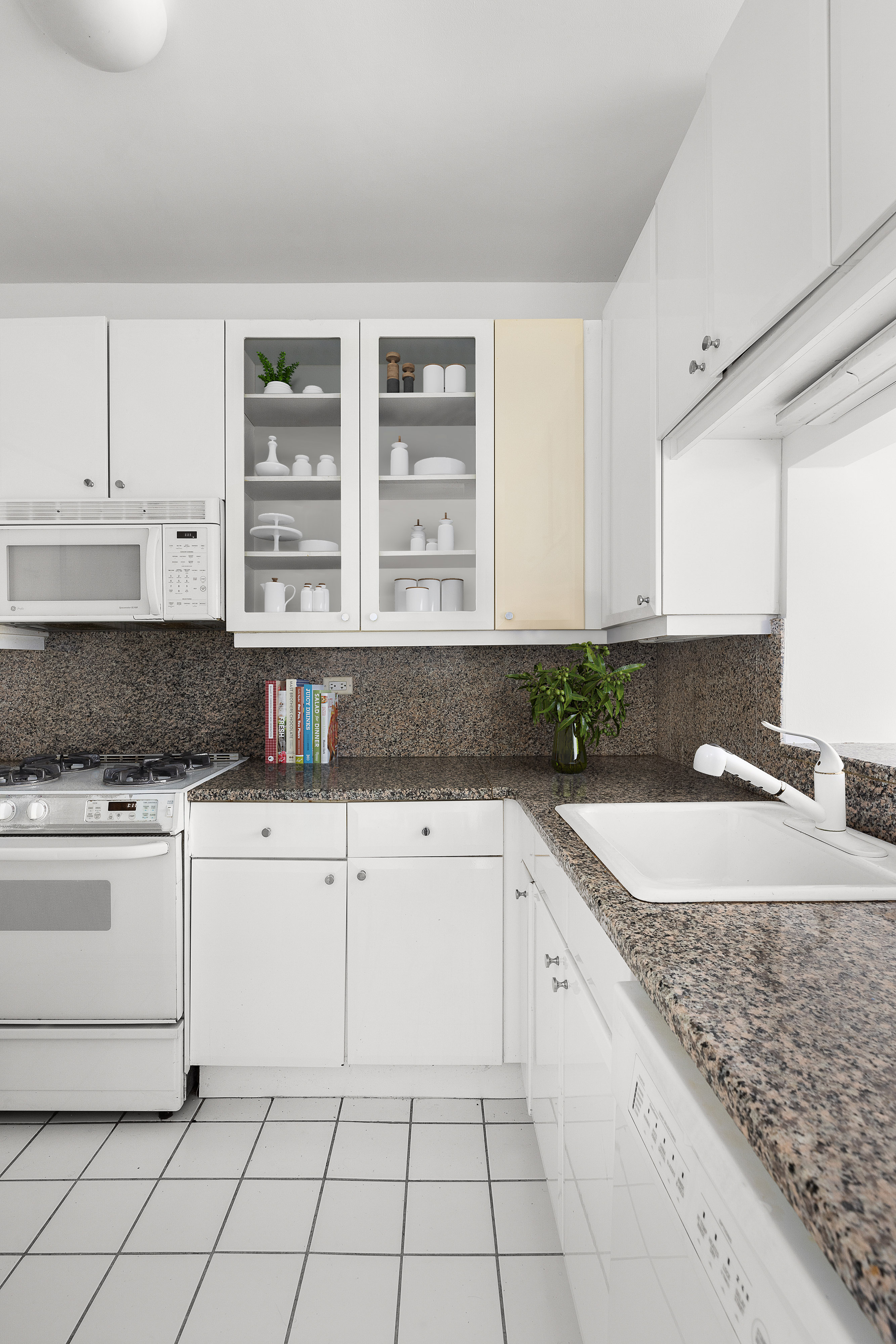 200 Riverside Boulevard, Unit 15F Manhattan, NY 10069 - Photo 9 of 11 a kitchen with granite countertop white cabinets and white appliances