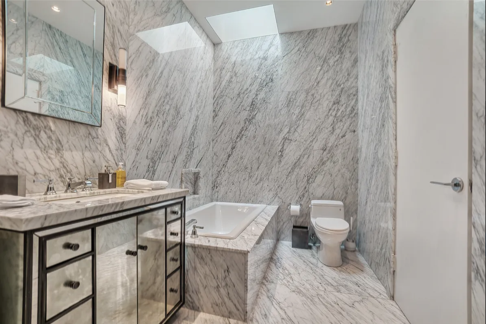 145 Spring Street, Unit PH Manhattan, NY 10012 - Photo 4 of 10 a bathroom with a sink a toilet and a mirror