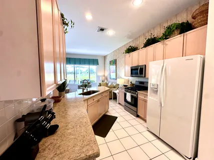 a kitchen with a refrigerator a stove a sink dishwasher and wooden cabinets with wooden floor